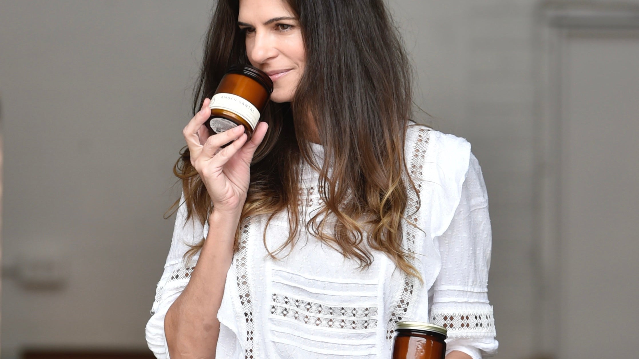 bia candle co creator Bia Antunes pleasantly wiffs a scented soy candle in her Sarasota, Florida studio.