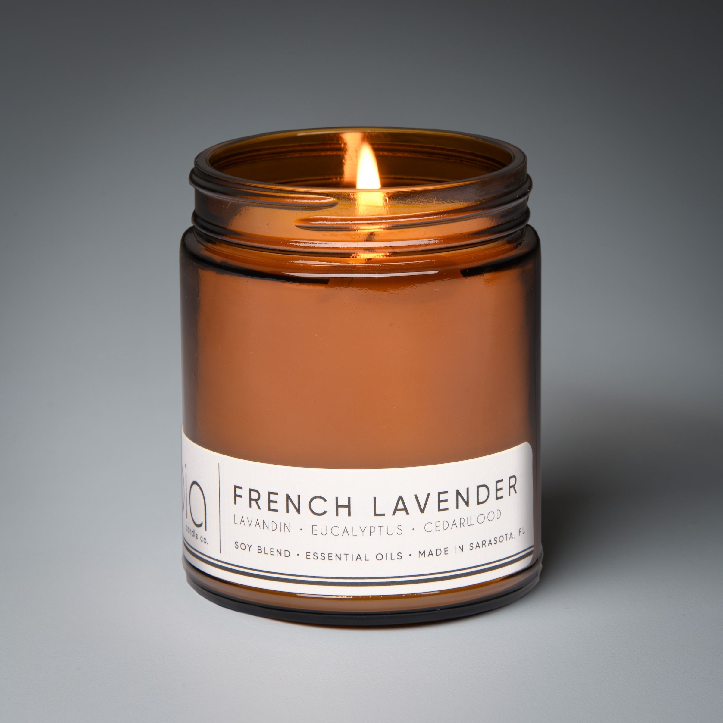 french lavender classic candle with gray background and wick lit