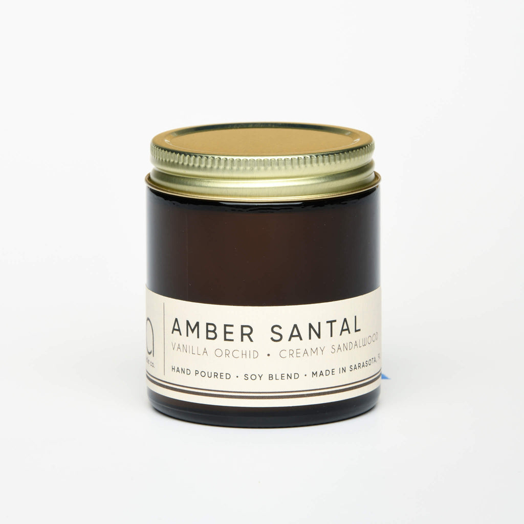 unlit and lidded petite single wick amber santal soy candle on white background