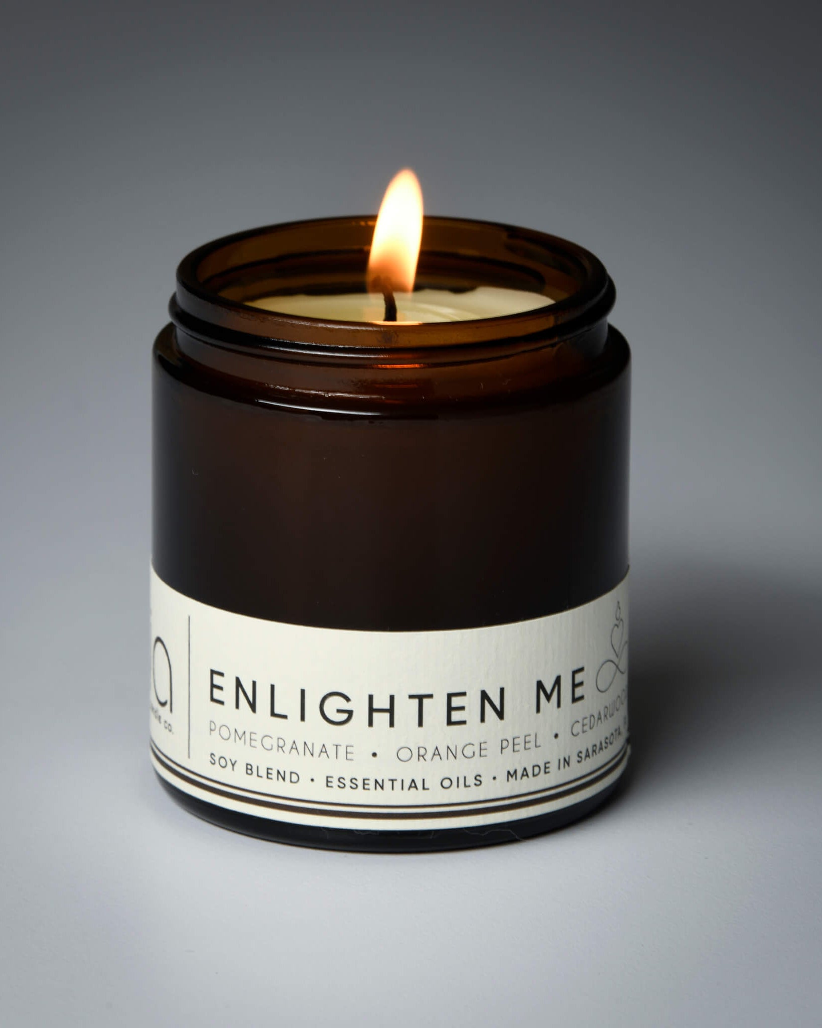 lit petite single wick enlighten me soy candle on grey background