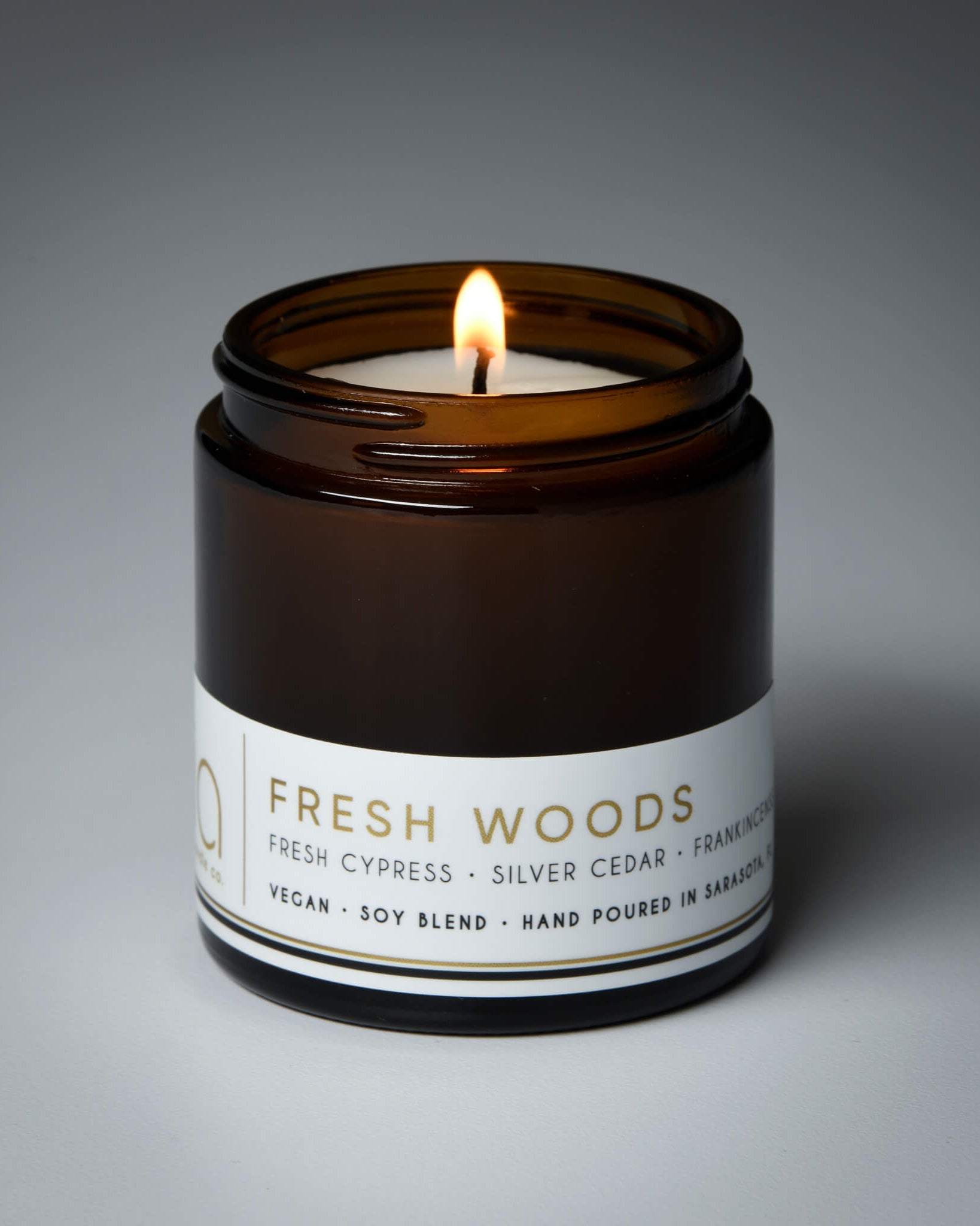 lit petite single wick fresh woods soy candle on grey background