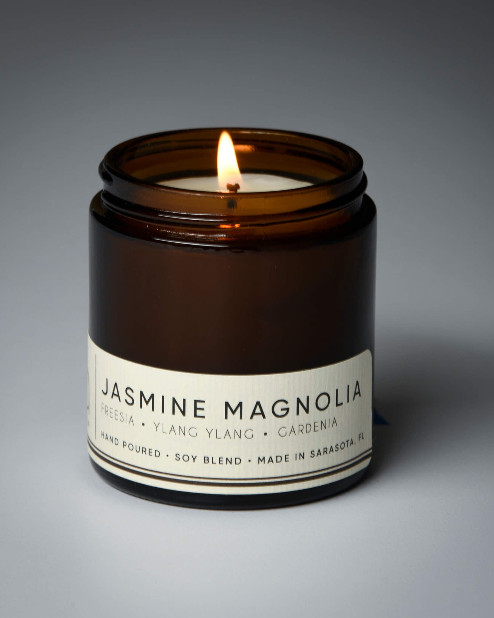 lit petite single wick jasmine magnolia soy candle on grey background