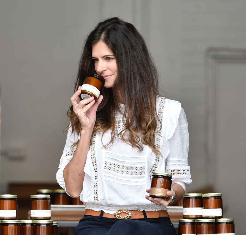 bia candle co creator Bia Antunes pleasantly wiffs a scented soy candle in her Sarasota, Florida studio.