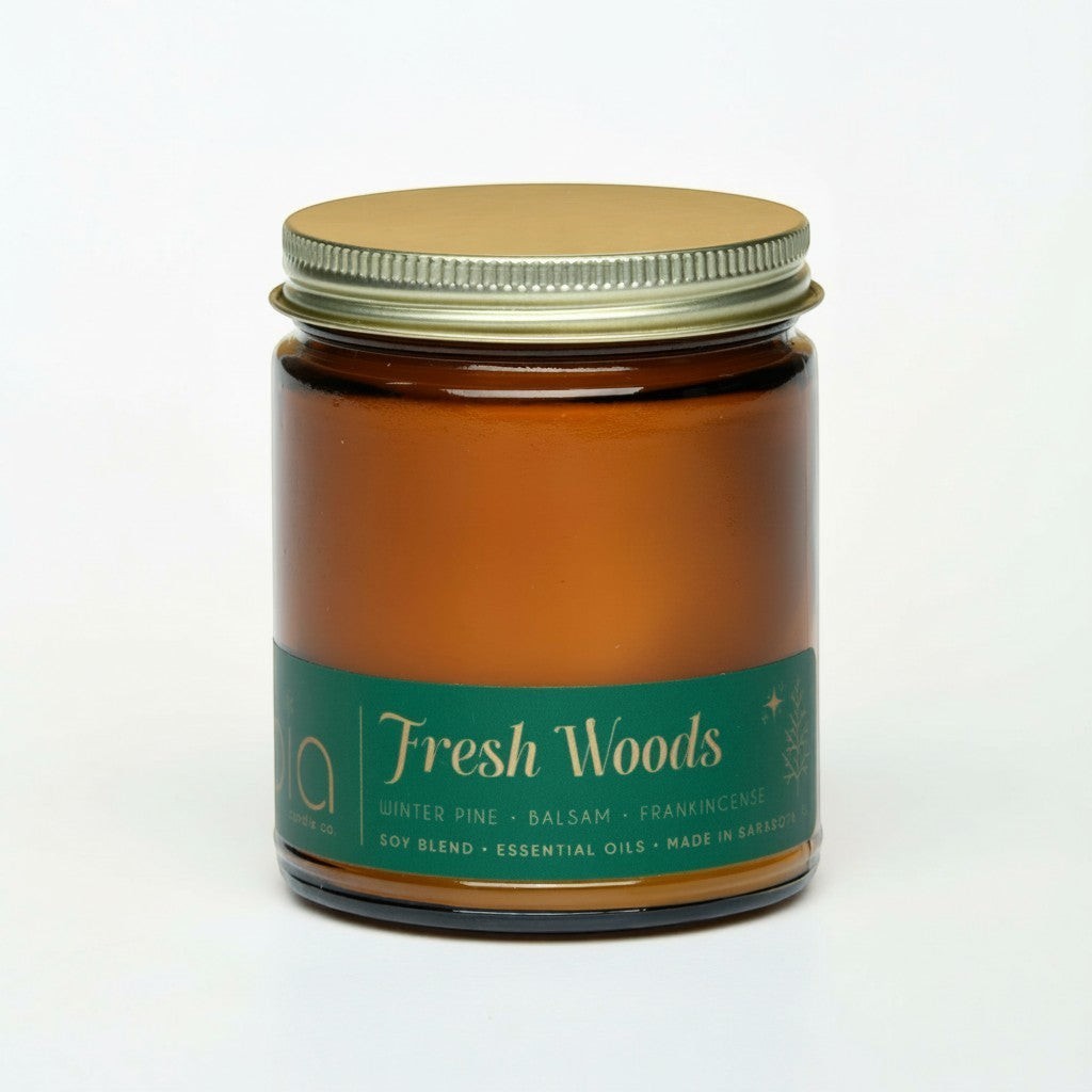 Bia Candle Co Fresh Woods soy blend candle in an amber glass jar with a gold lid and green label.