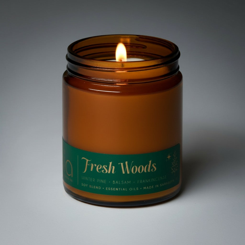 Bia Candle Co Fresh Woods limited edition soy candle in an amber glass jar with a lit wick and green label