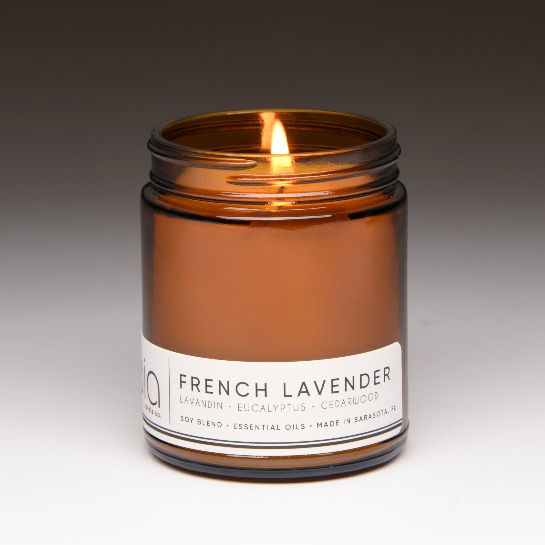 french lavender classic candle with gray background and wick lit