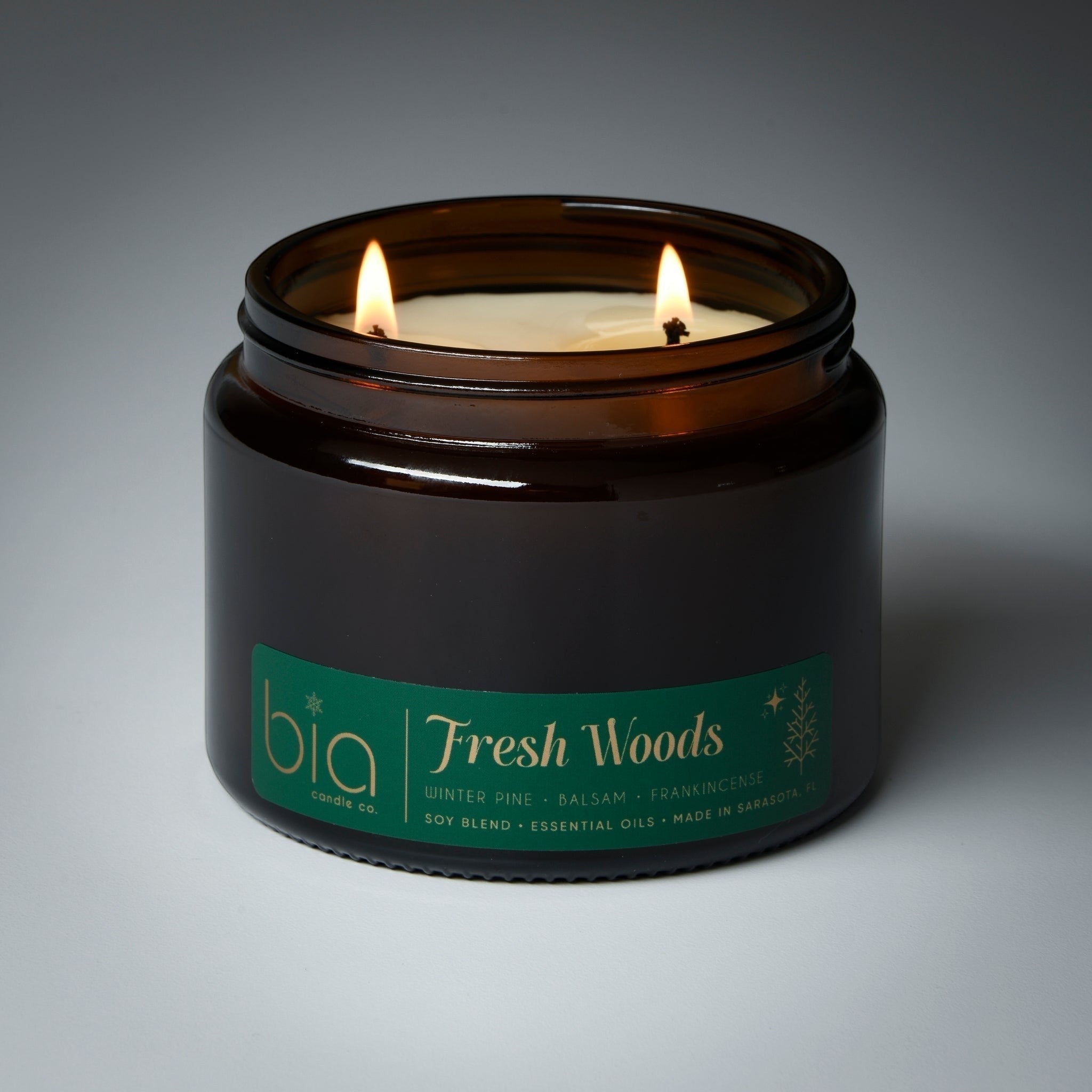 grande 2wick Candle in a brown jar labeled 'Fresh Woods' by bia on a gray background