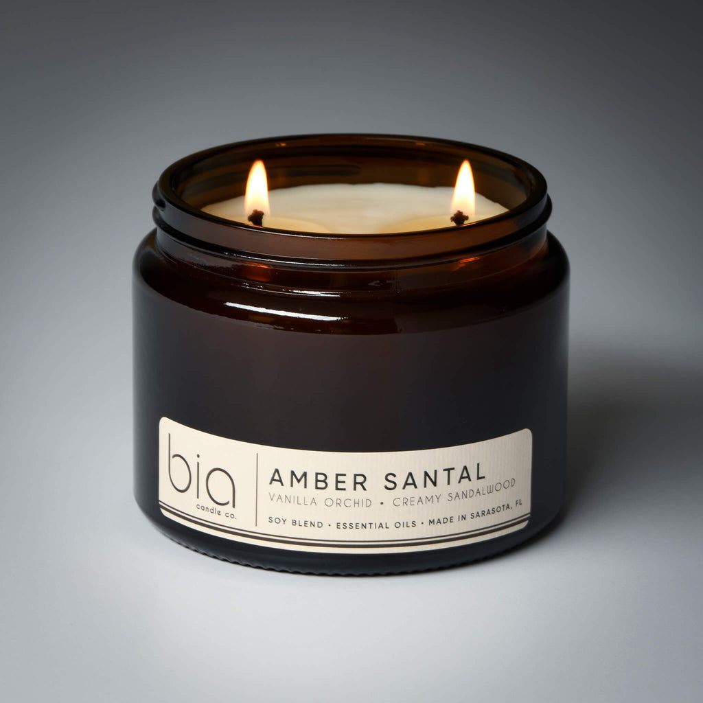 lit 2 wick amber santal soy candle on grey background