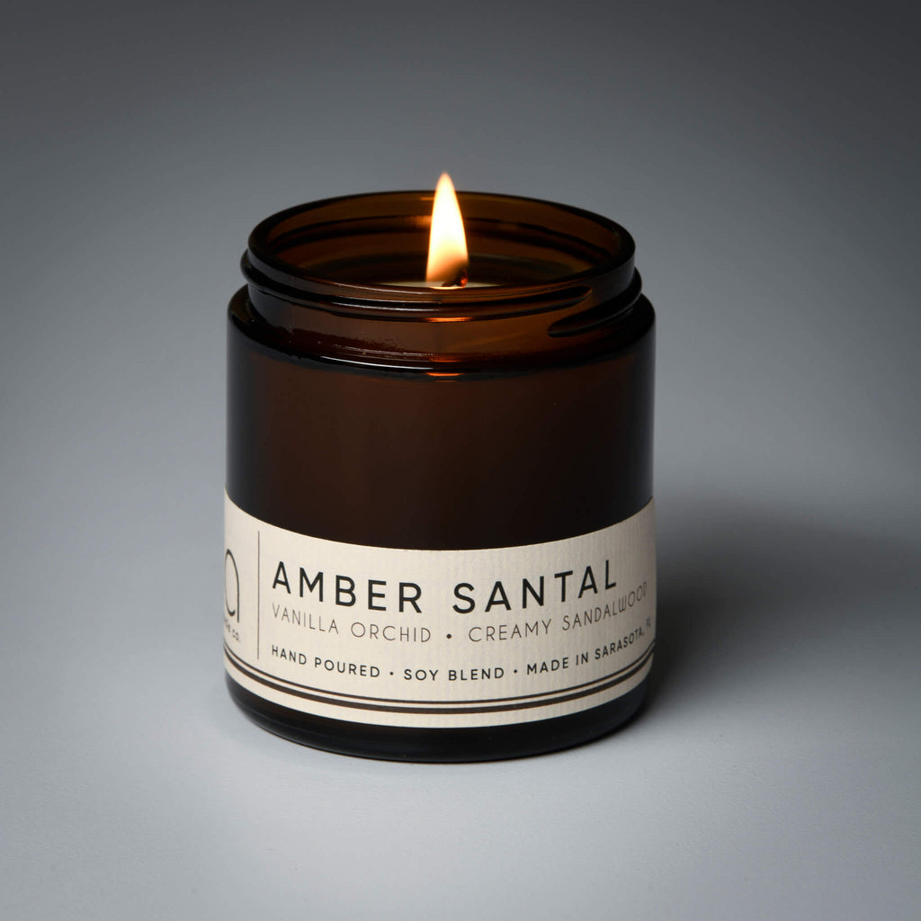 lit petite single wick amber santal soy candle on grey background