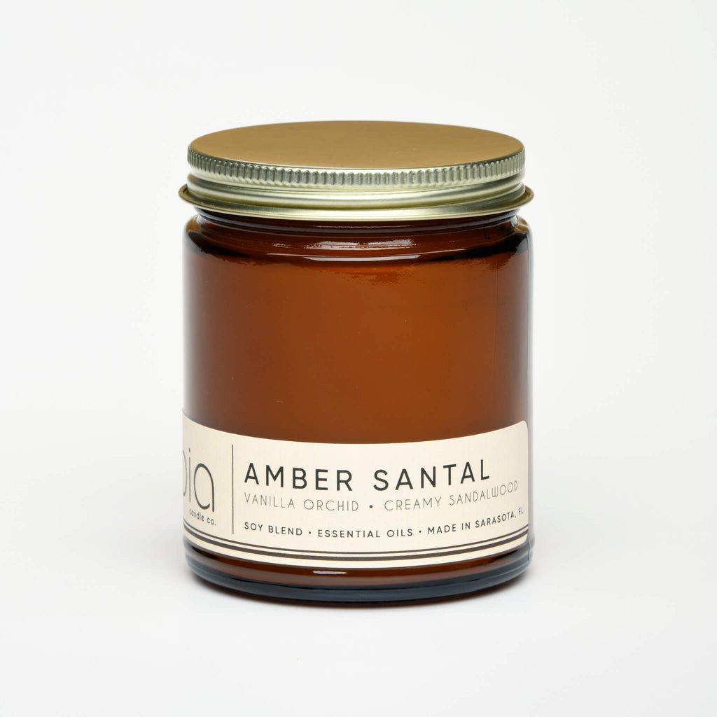unlit and lidded single wick amber santal soy candle on white background