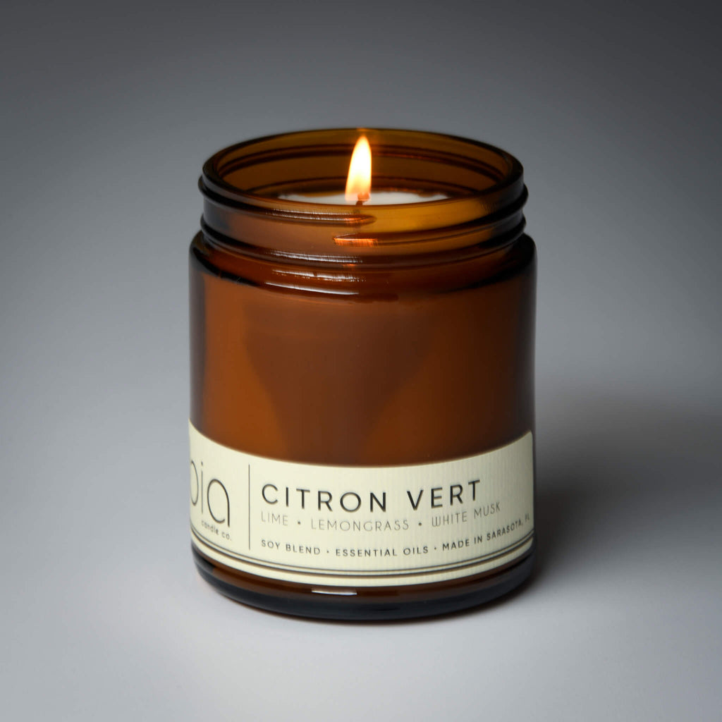 lit single wick citron vert soy candle on grey background