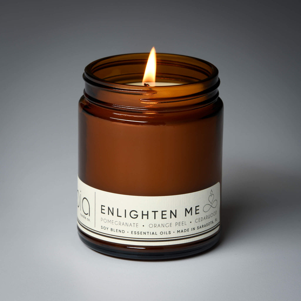 lit single wick enlighten me soy candle on grey background