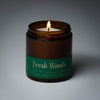 lit petite single wick holiday fresh woods soy candle on grey background