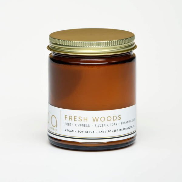 unlit and lidded single wick fresh woods soy candle on white background