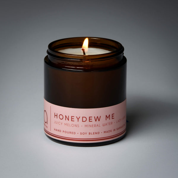 lit petite single wick honey dew me soy candle on grey background