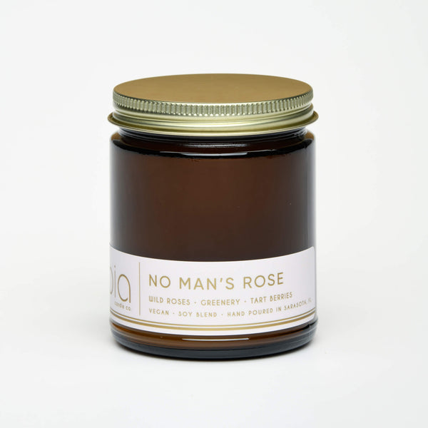 unlit and lidded single wick no mans rose soy candle on white background